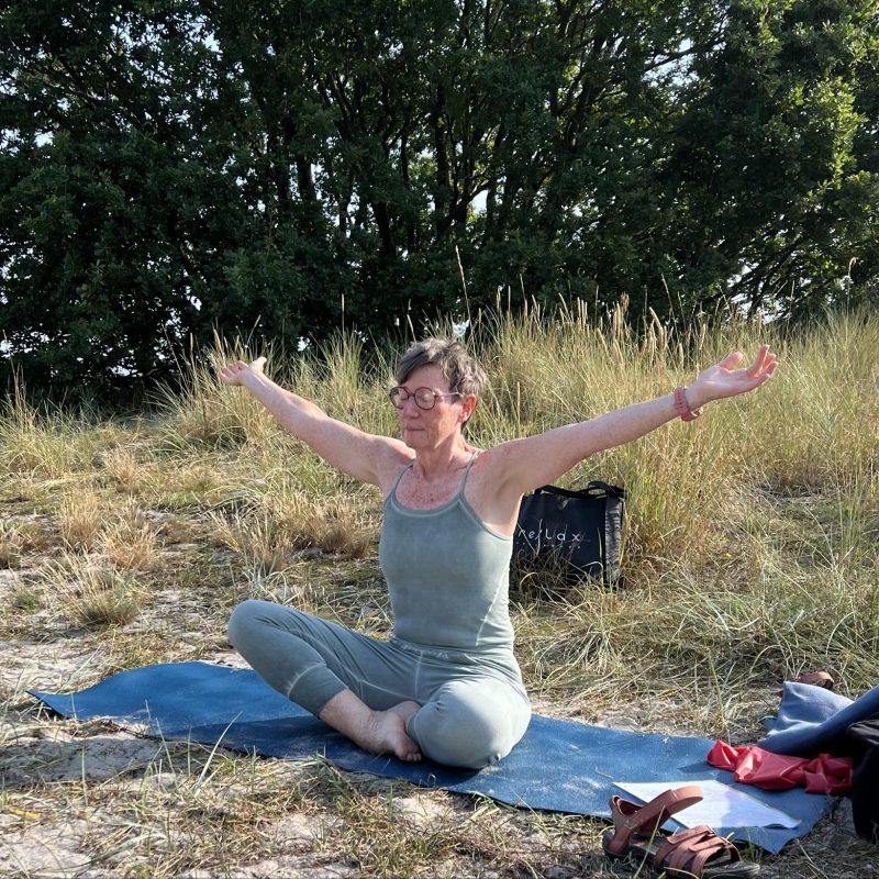 Udendørs yoga i sandet ved Melsted Strand.