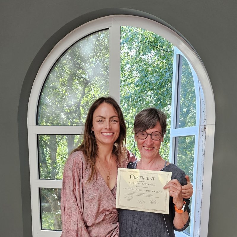 To deltagere med certifikat efter yoga nidra-uddannelse.